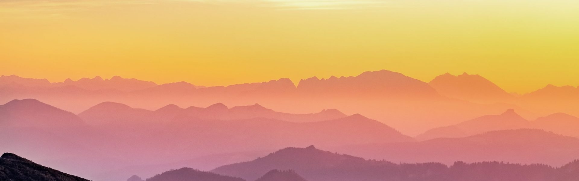 rainbow colored sunset over misty mountains